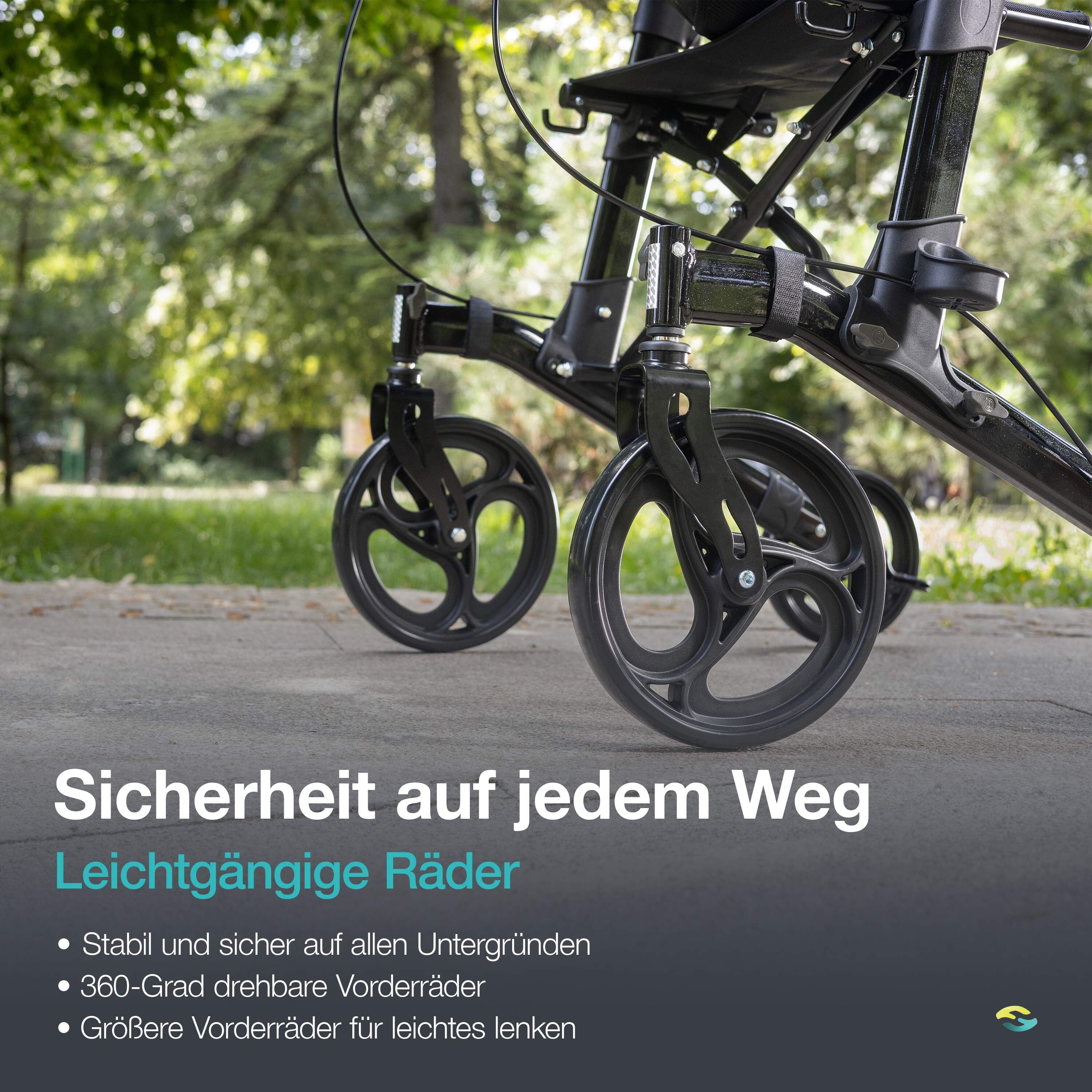 Close-up van de wielen van een zwarte rollator op een trottoir.