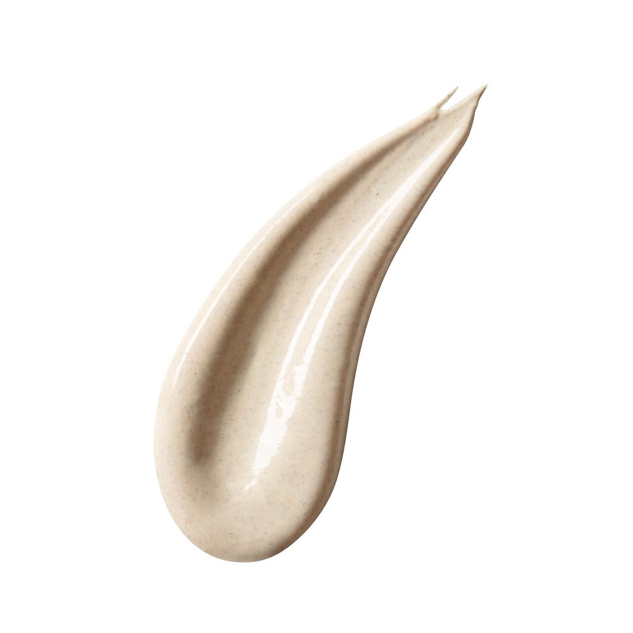 Uitgesmeerde crème. Lichtbeige kleur. Glanzende textuur. Op witte achtergrond.