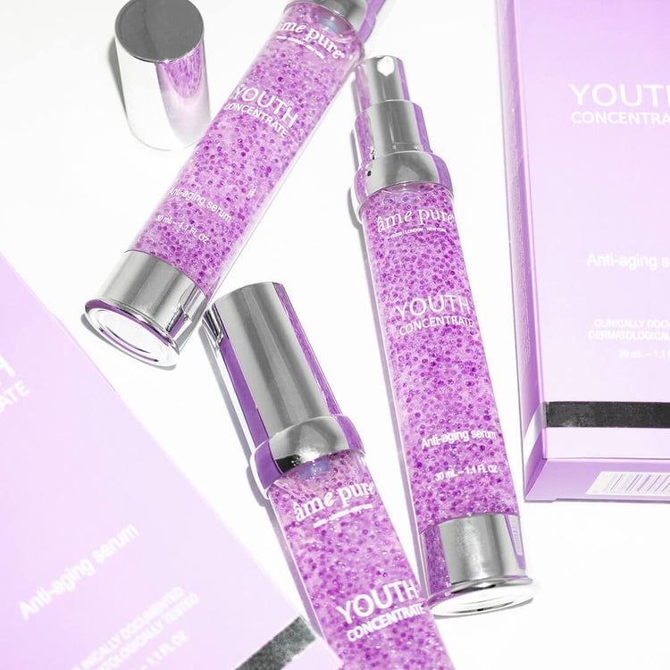 Drie flacons Youth Concentrate Serum, één geopend, met verpakking.
