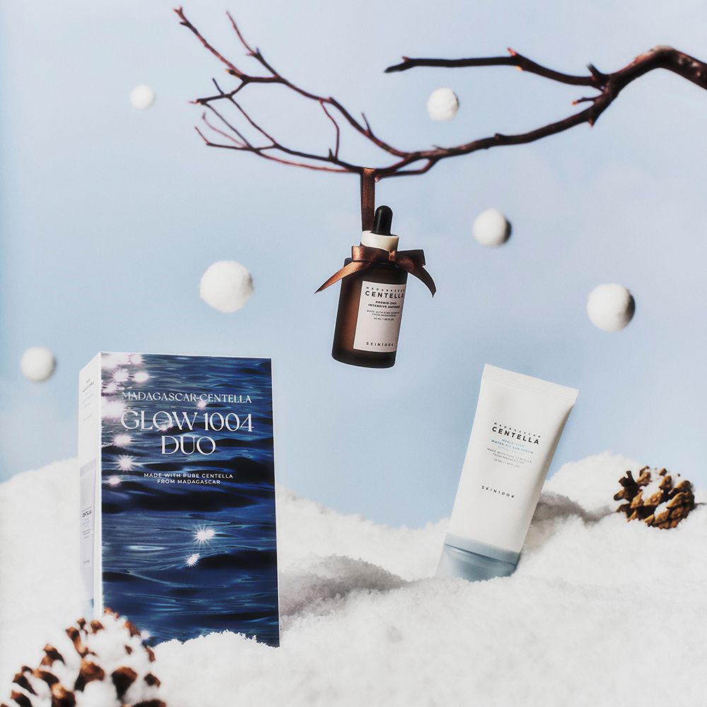 Duo-set met serum, ampul en verpakking. Ampul hangt aan tak. Serum en verpakking op de grond. Sneeuwlandschap.