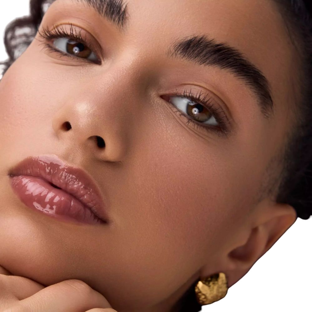 Close-up van een gezicht. Gevormde lippen, gouden oorbel. Glanzende lippen. Huidskleur: licht.