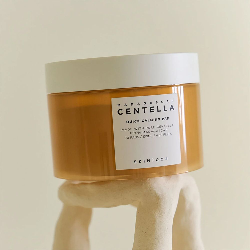 SKIN1004 Madagascar Centella Quick Calming Pad in een amberkleurige pot met wit deksel, op een witte voet.