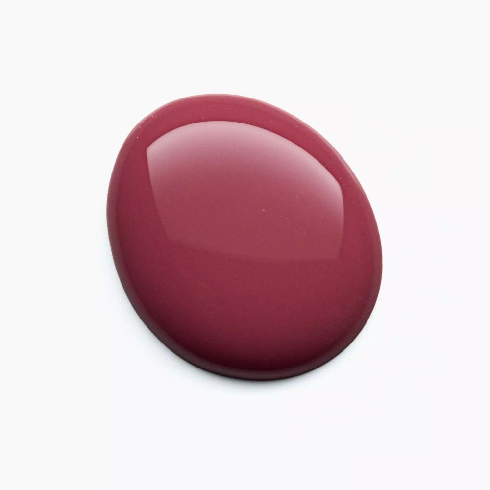 Tache de vernis à ongles rose sur fond blanc. Surface brillante.