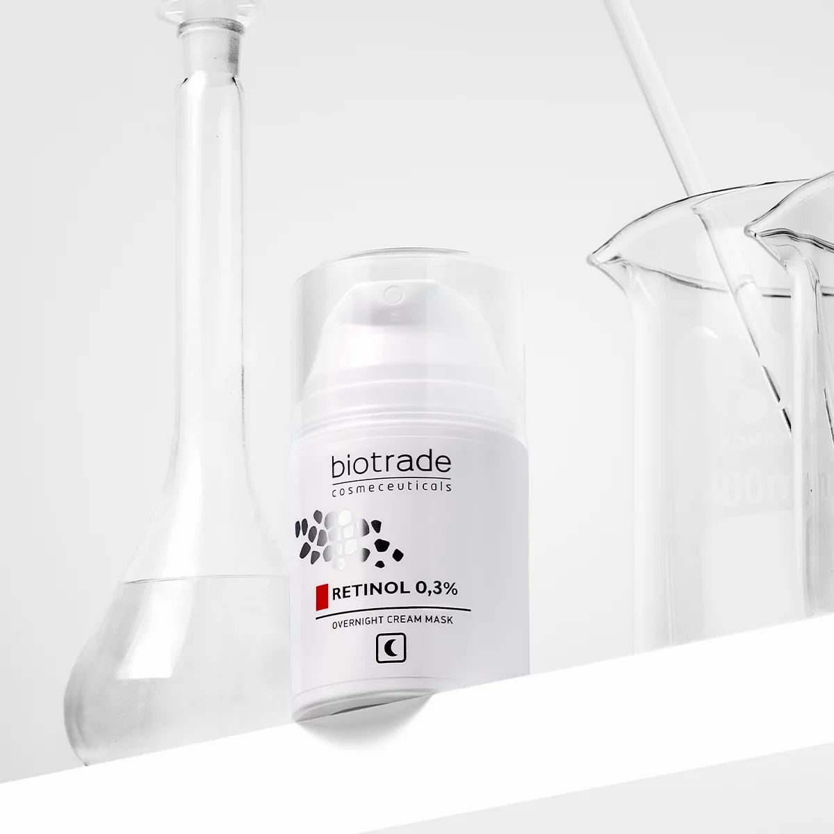 Flacon blanc Biotrade, Retinol 0,3% et masque de nuit. À côté d'équipements de laboratoire.