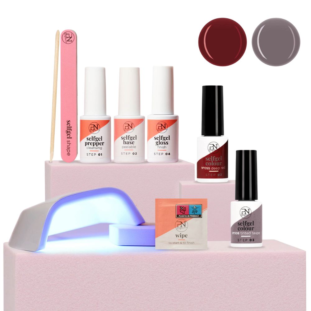Kit de soins des ongles avec lampe UV, lime, bâtonnet, lingettes et vernis rouge et taupe. Logo PN visible.