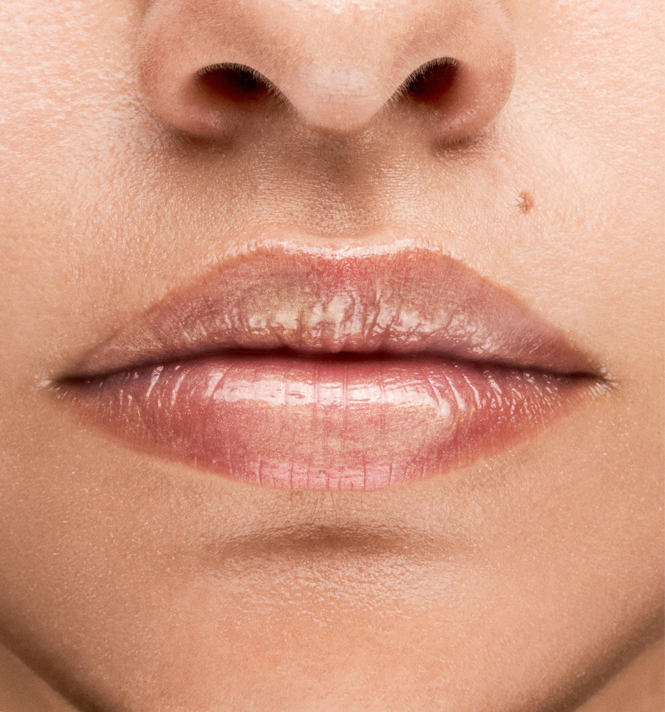 Gros plan sur des lèvres avec du gloss brillant.