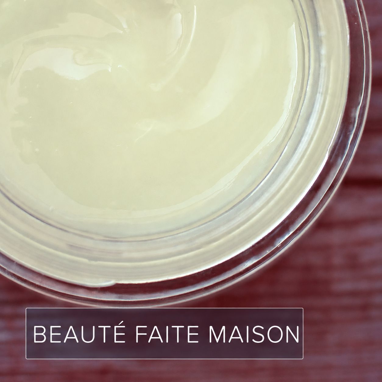 Gros plan de la texture crémeuse du beurre de karité dans un pot.