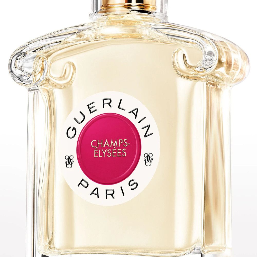 Flacon de parfum avec étiquette. Autocollant rond avec texte: GUERLAIN, CHAMPS-ELYSEES, PARIS. Cercle rose.