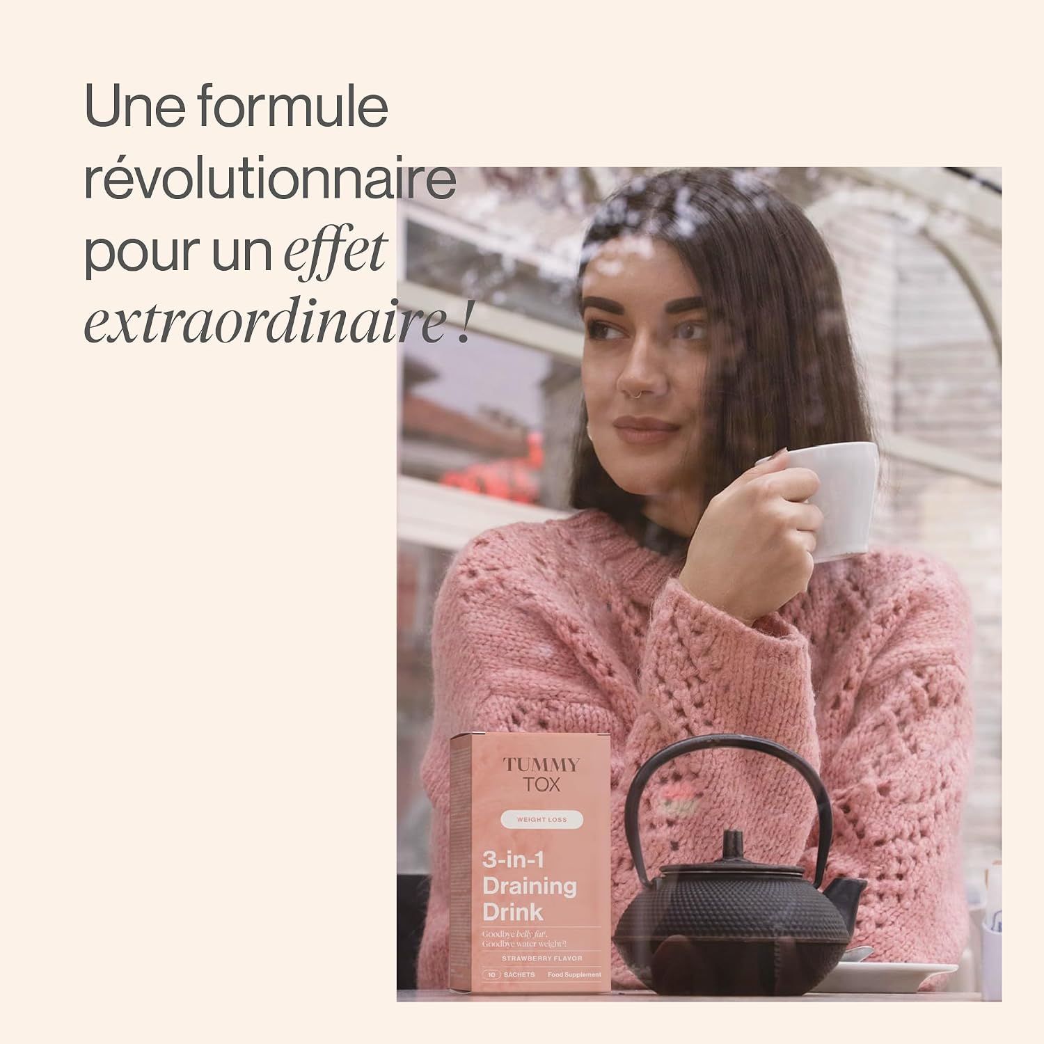 Une femme boit dans une tasse à côté d'une théière et d'une boîte de Tummy Tox 3-in-1 Draining Drink.