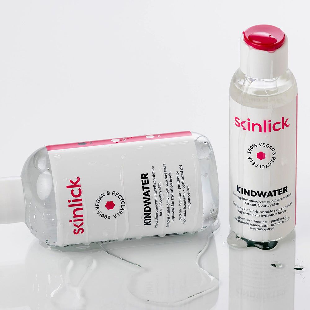 Deux bouteilles de SKINLICK Kindwater eau micellaire, une couchée. Liquide transparent.