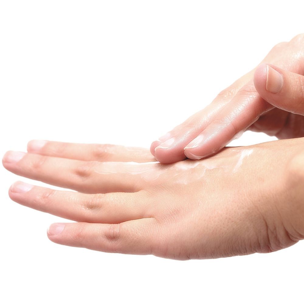 Close-up van een hand die crème op de andere hand aanbrengt. Huid is zichtbaar.
