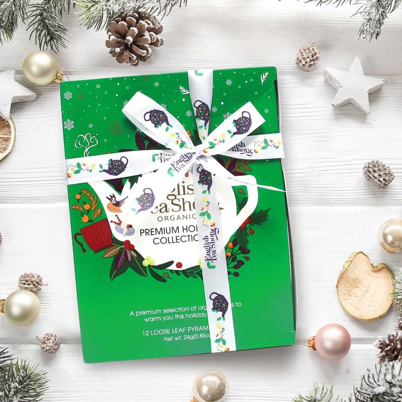 Groene geschenkdoos met lint. Opschrift: English Tea Shop, Holiday Collection. Met theezakjes.