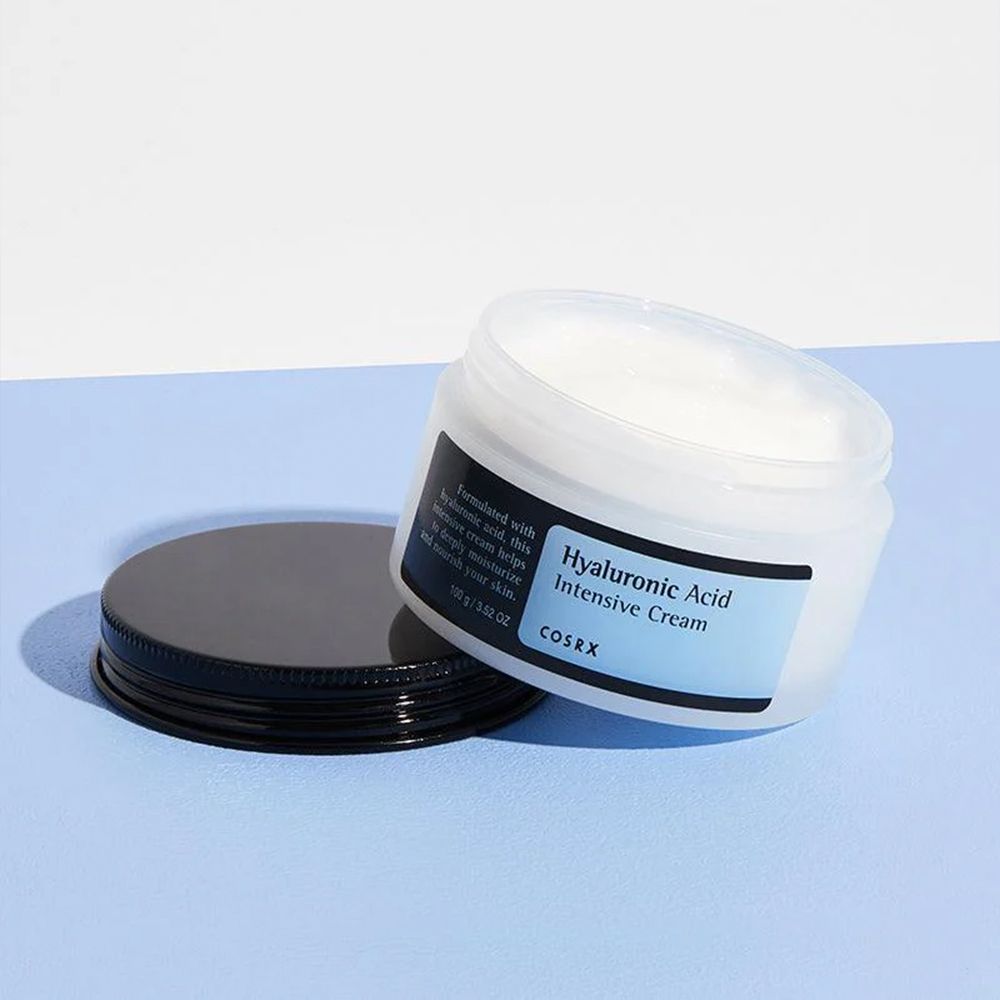 Crème intensive à l'acide hyaluronique COSRX dans un pot blanc avec un couvercle noir.