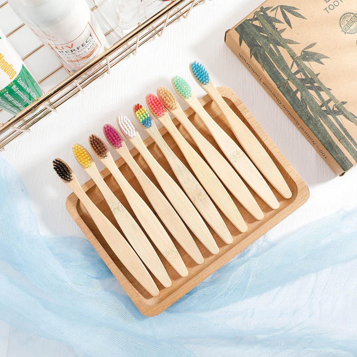 Dix brosses à dents en bambou avec des poils colorés sur un plateau en bois.