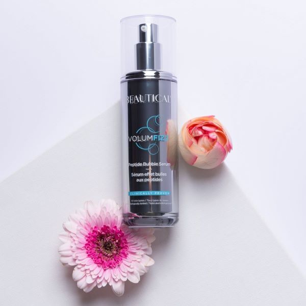 Beautical Volumfizz Peptidbubbleserum. Zilveren fles met verstuiver. Productnaam en details op etiket. Met bloemen.
