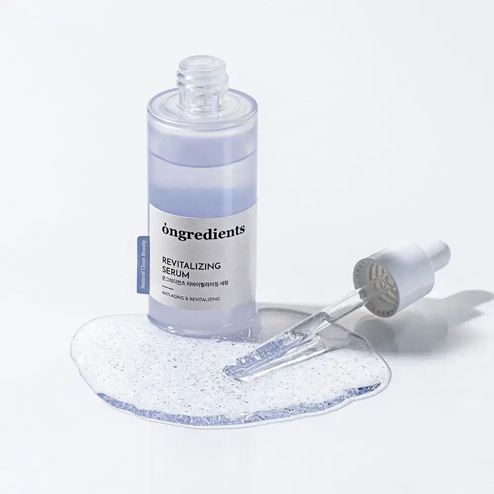 ONGREDIENTS Revitalizing Serum. Fles en pipet met serum op witte achtergrond. Productnaam en tekst.