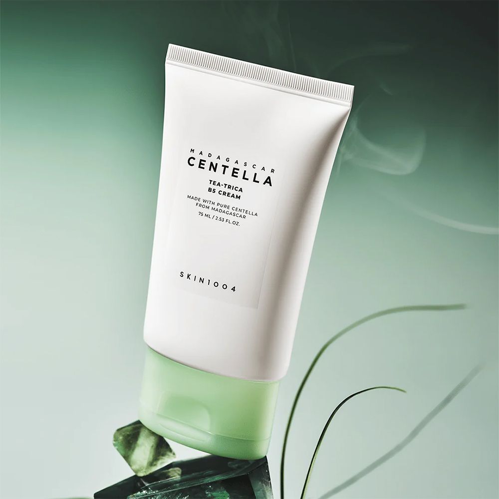 Tube SKIN1004 Centella Tea-Trica B5 Cream sur des pierres vertes.