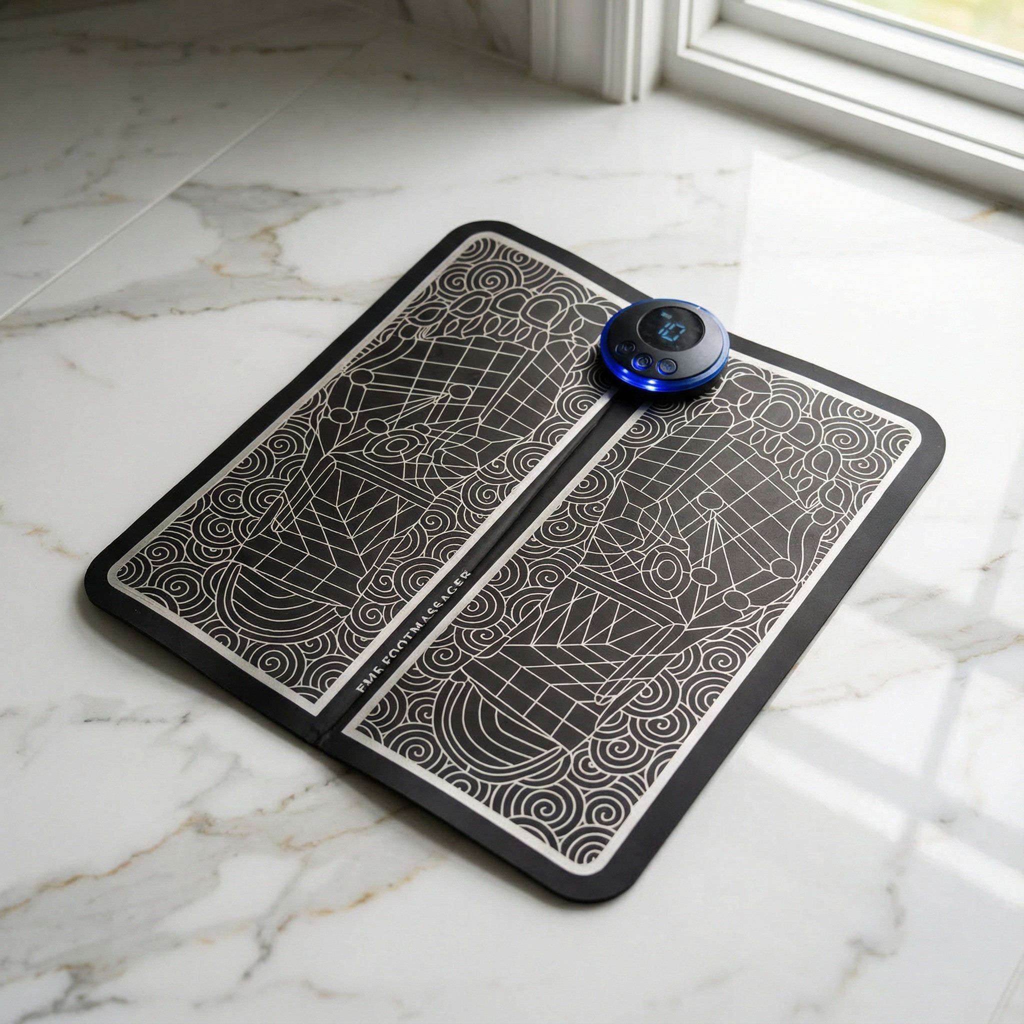 Tapis EMS noir avec écran et motif de réflexologie plantaire.