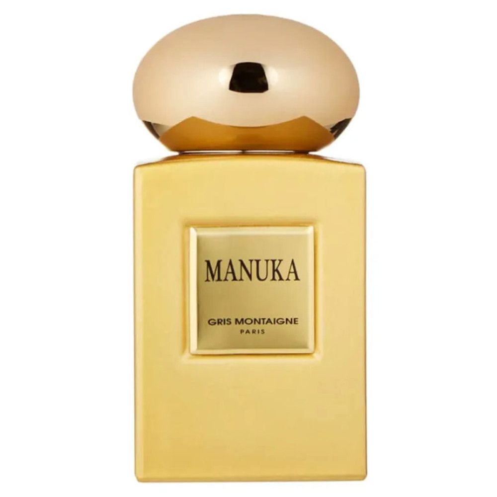 Goudkleurige flacon met dop. Opschrift MANUKA en GRIS MONTAIGNE PARIS op vierkant etiket.