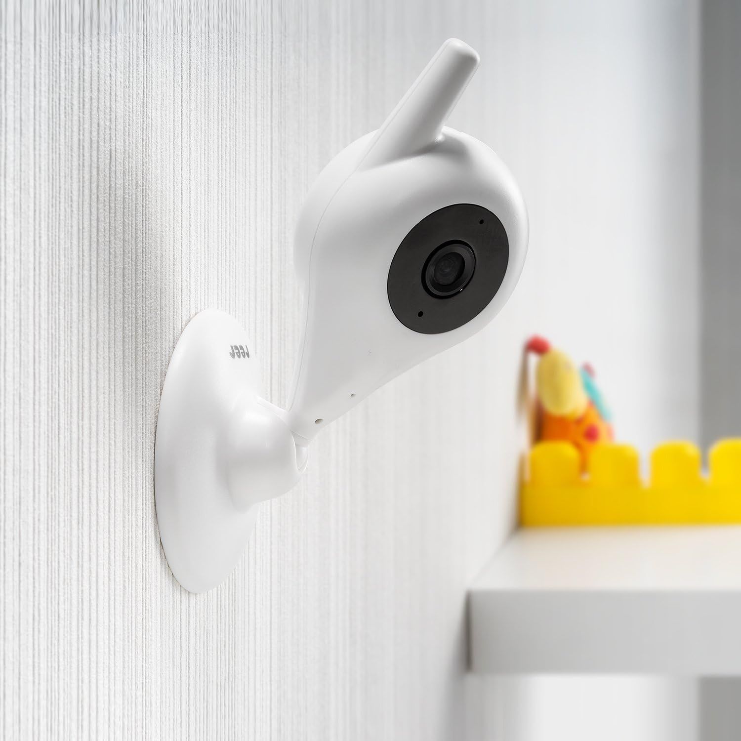 Witte babyfoon camera met draaibare kop en antenne, gemonteerd op een gestreepte muur.