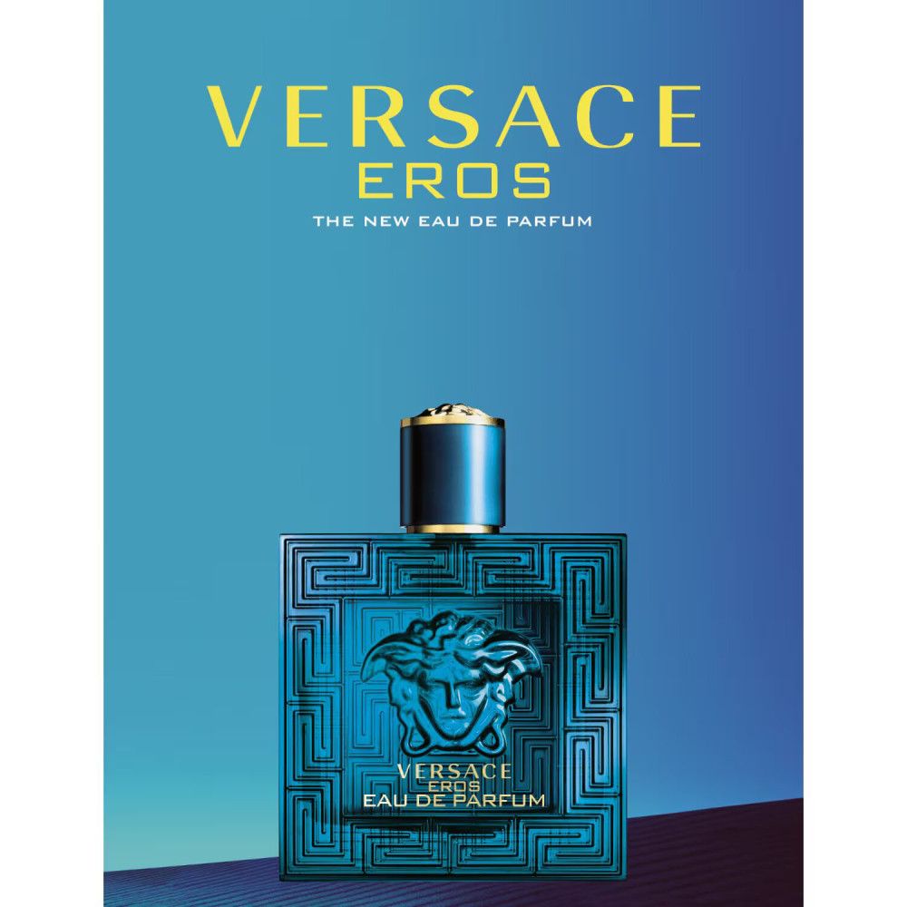 Blauwe parfumfles met gouden dop. Opschrift VERSACE EROS. Vierkante vorm met reliëfpatroon.