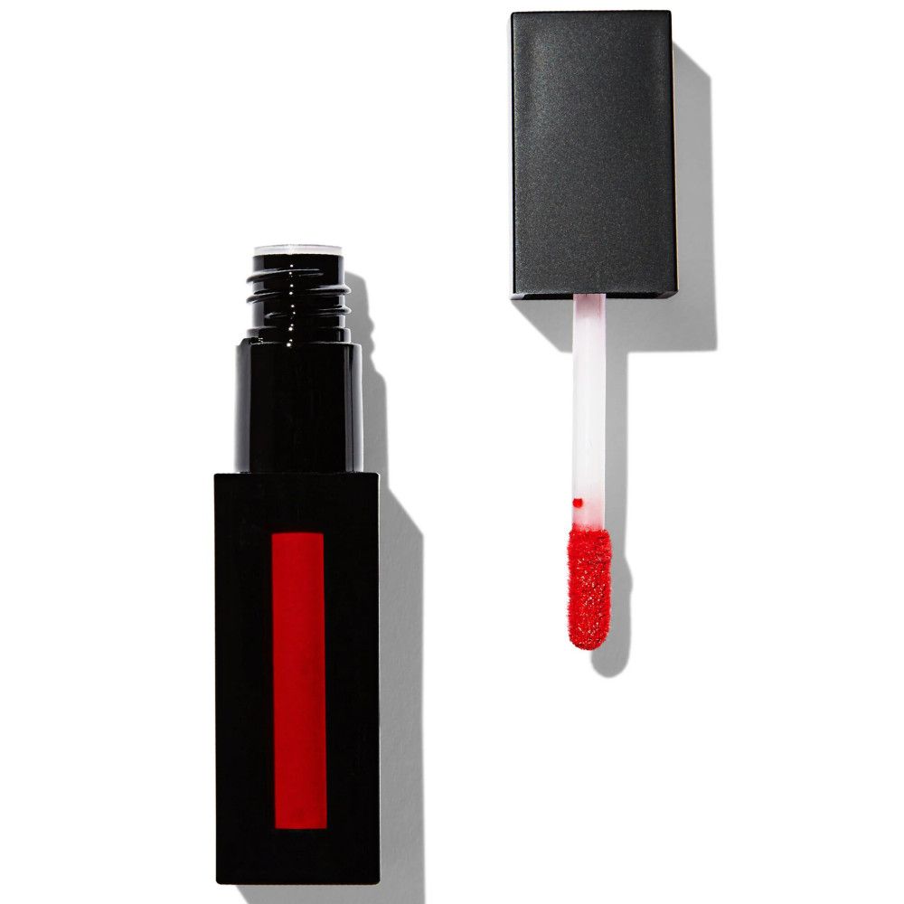 Tube de gloss noir rectangulaire avec bande rouge. Bouchon à côté, applicateur avec couleur rouge.