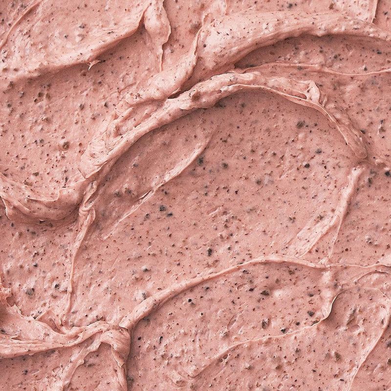 Close-up van het roze gezichtsmasker. Textuur met donkere deeltjes.