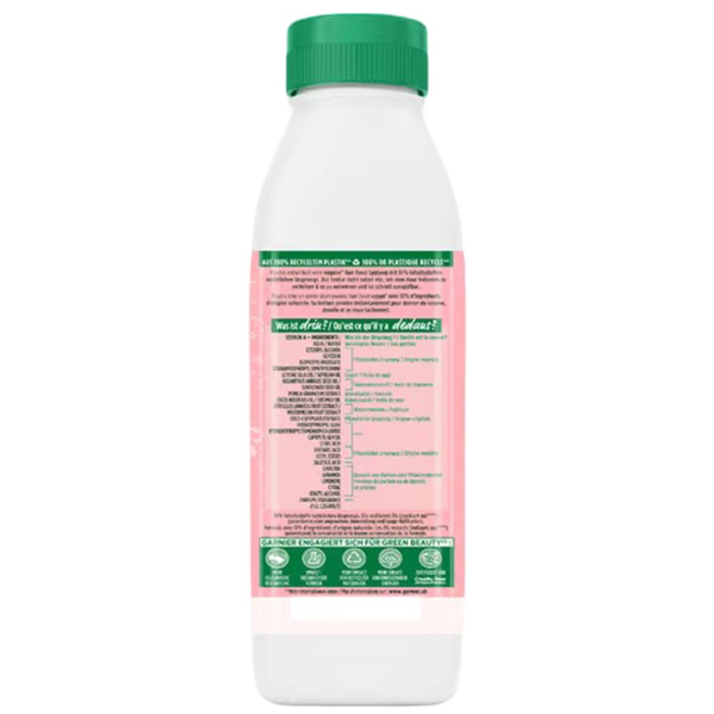 Bouteille de Garnier Fructis. Étiquette rose avec texte. Bouchon vert. Certifications de durabilité.