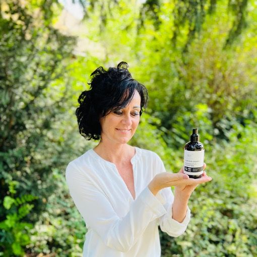 Une femme tient un flacon de gel douche. Inscription : AQUA RELATIVE SHOWER GEL. Produit biologique certifié. Logos.