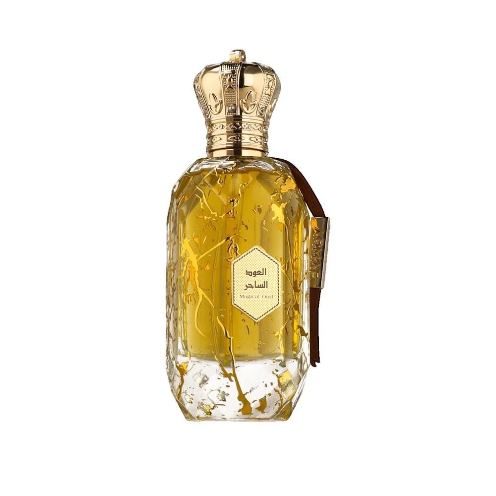 Flacon de parfum doré avec bouchon couronne. Étiquette avec écriture arabe. Ruban en cuir marron.