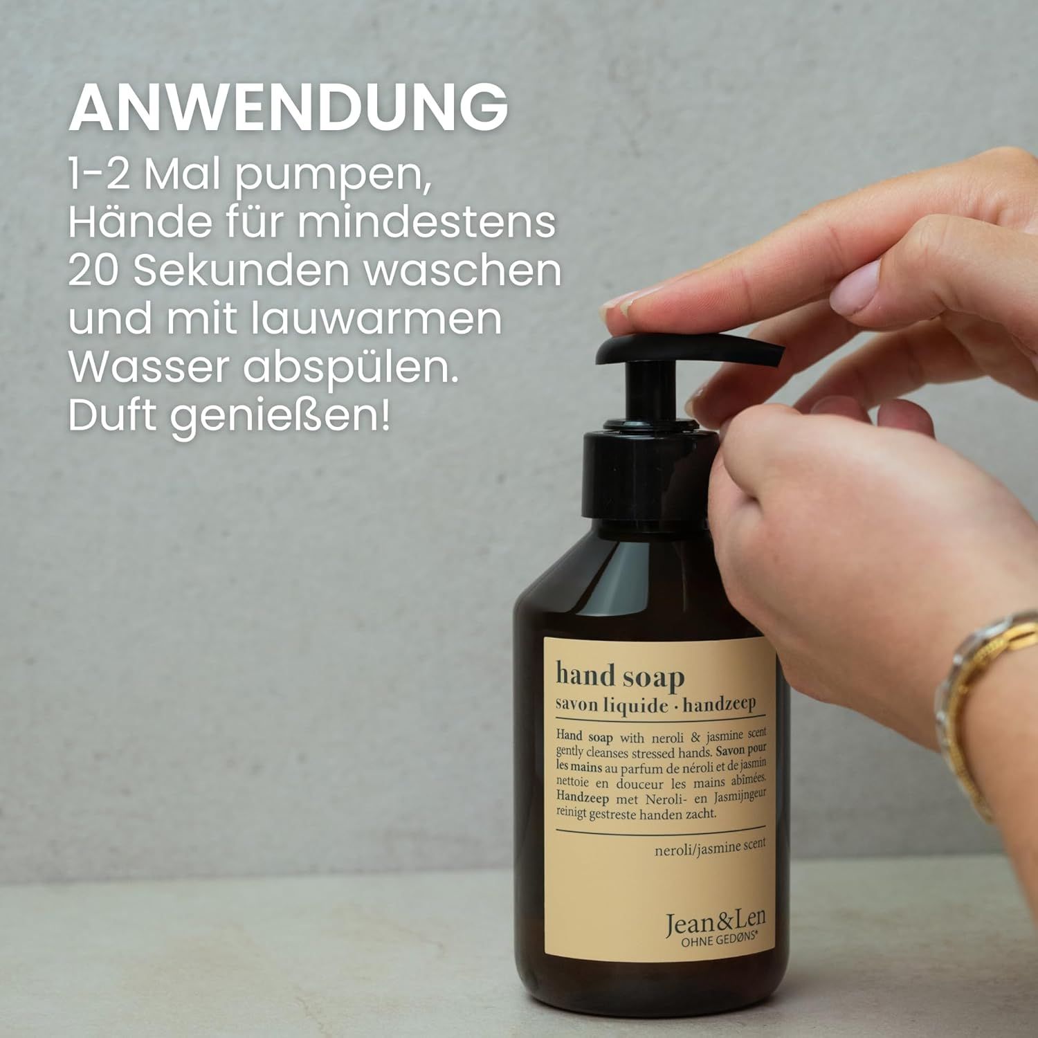 Handen pompen handzeep uit bruine fles met zwarte pomp. Opschrift: Hand Soap, Neroli & Jasmin geur, Jean & Len.