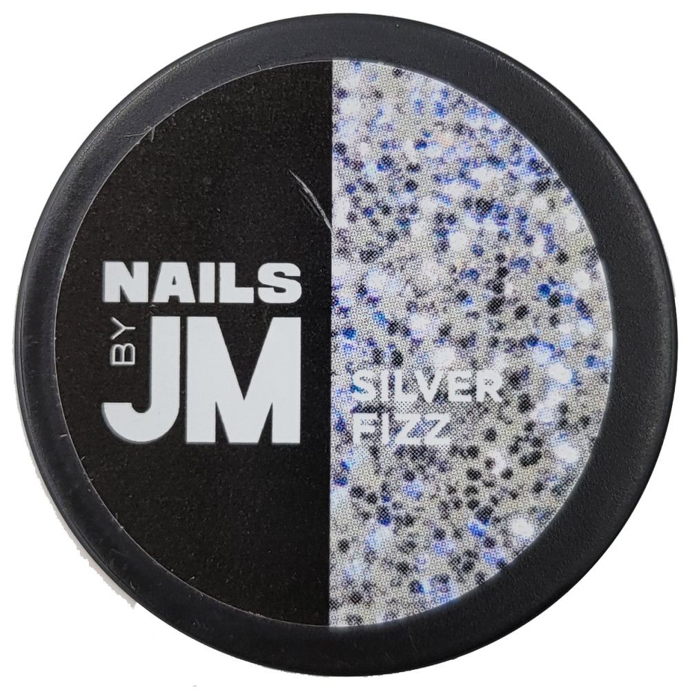 Récipient rond avec couvercle noir. Inscription "NAILS BY JM" et "SILVER FIZZ". Le contenu est argenté avec des paillettes.
