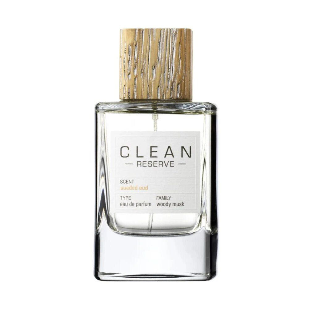 Clean Reserve Sueded Oud Eau de Parfum in glazen fles met houten dop. Etiket toont 'CLEAN RESERVE', 'SCENT: sueded oud', 'TYPE: eau de parfum', 'FAMILY: woody musk'.
