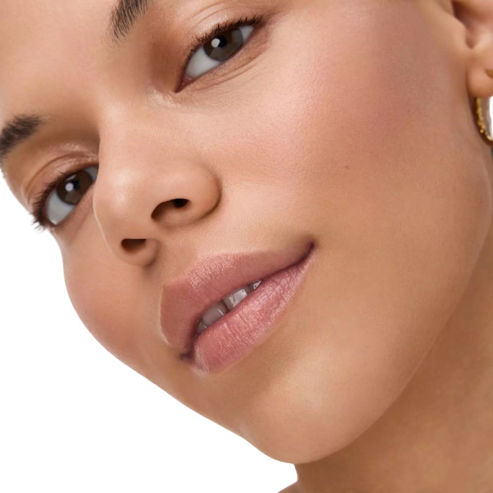 Gros plan d'un visage. Les lèvres sont recouvertes d'un baume à lèvres rose clair.
