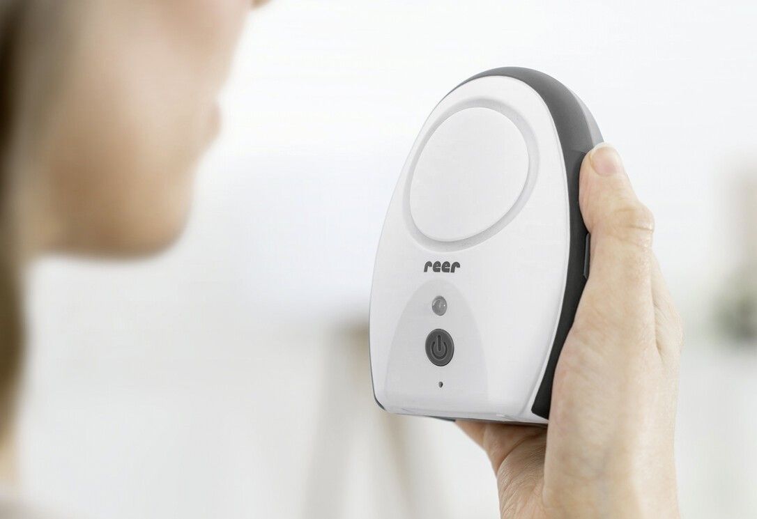 Babyphone dans la main, avec veilleuse et motif oiseau.
