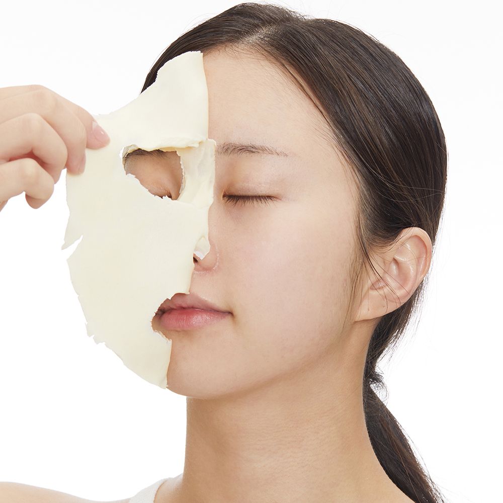 Une femme applique un masque facial couvrant la moitié de son visage.