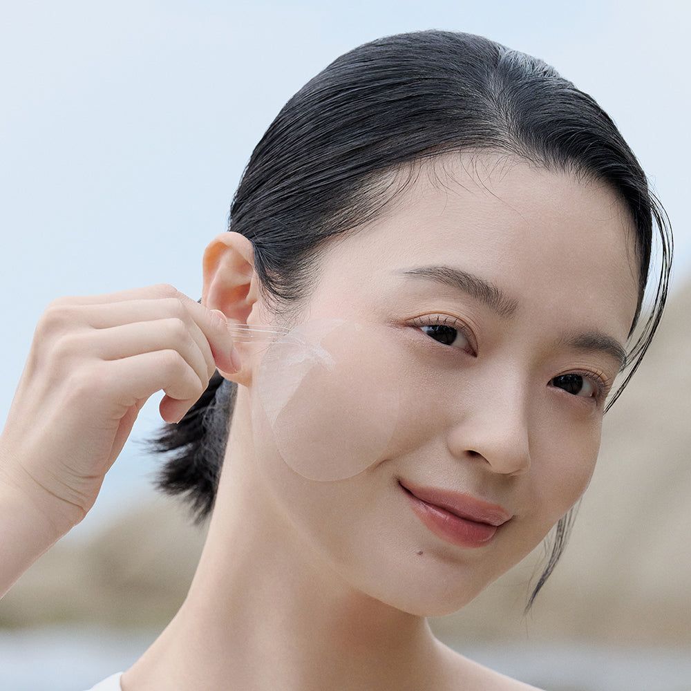Femme avec un pad transparent sur la joue. Le pad est rond et transparent. Arrière-plan: nature, clair.