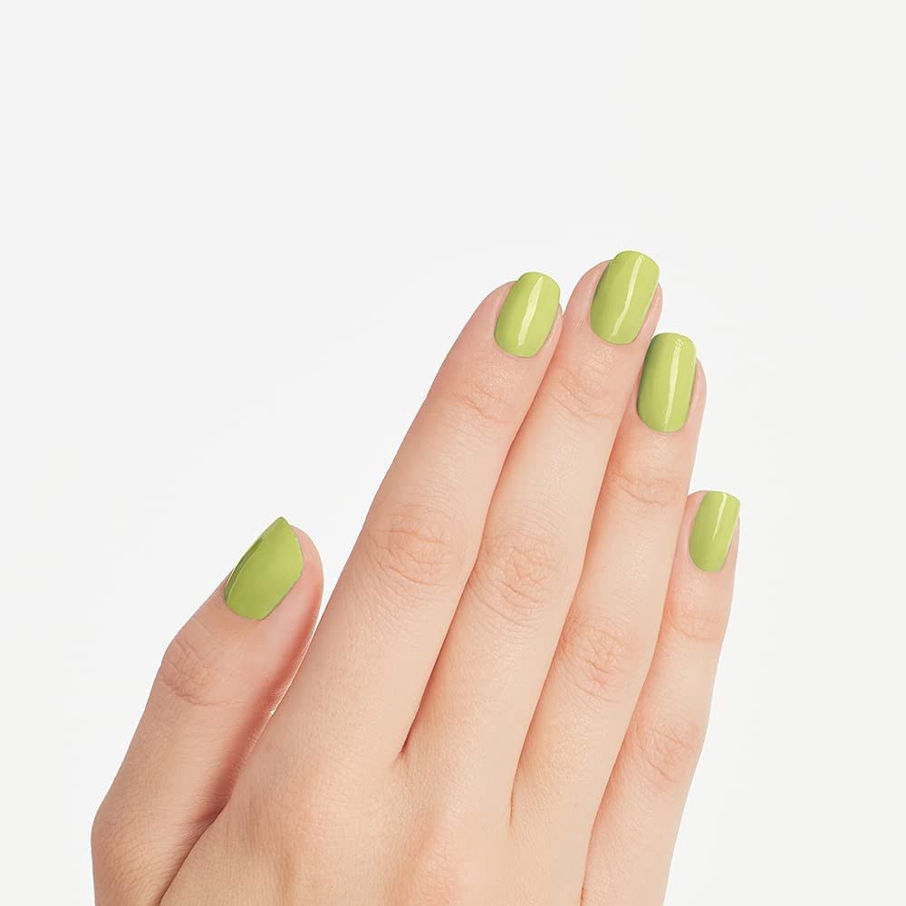Hand met vijf gelakte nagels. De nagels zijn ovaal en gelakt met groene nagellak. Lichte achtergrond.