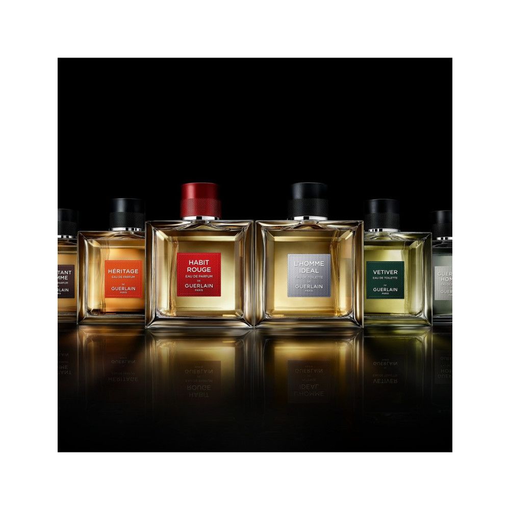 Verschillende Guerlain parfumflacons. Vierkante flacons met zwarte en rode doppen. Labels met namen en kleuren.