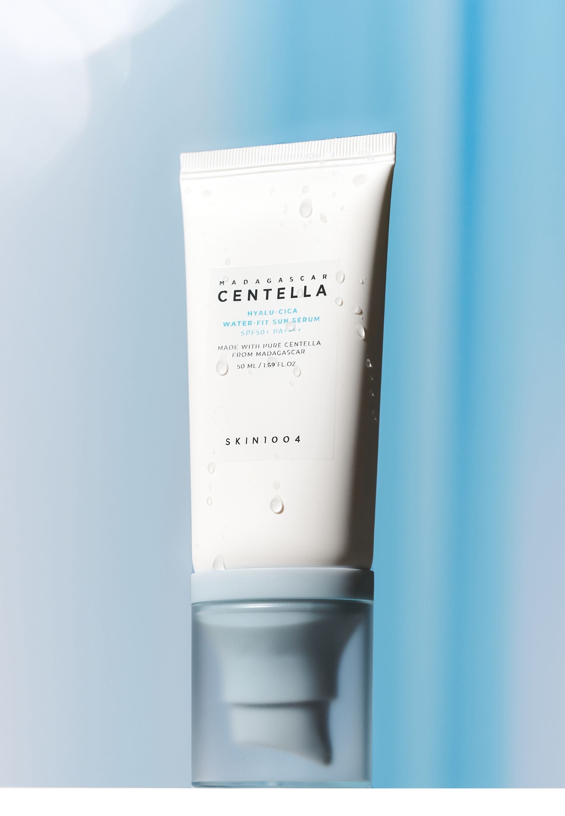 Witte tube met blauwe dop. Opschrift: MADAGASCAR CENTELLA HYALU-CICA WATER-FIT SUN SERUM. Merk SKIN1004.