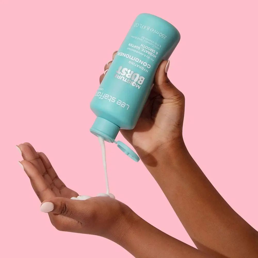 Handen houden een turquoise fles. Product wordt in de handpalm gegoten. Opschrift: Moisture Burst Hydrating Conditioner.