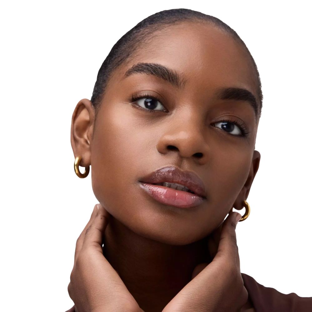 Portret van een vrouw met een donkere huid. Ze draagt gouden oorringen en heeft glanzende lippen.