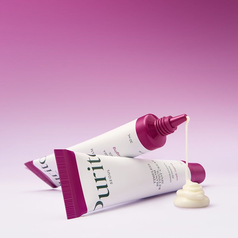 Deux tubes de crème PURITO. La crème coule d'un tube. Fond violet.