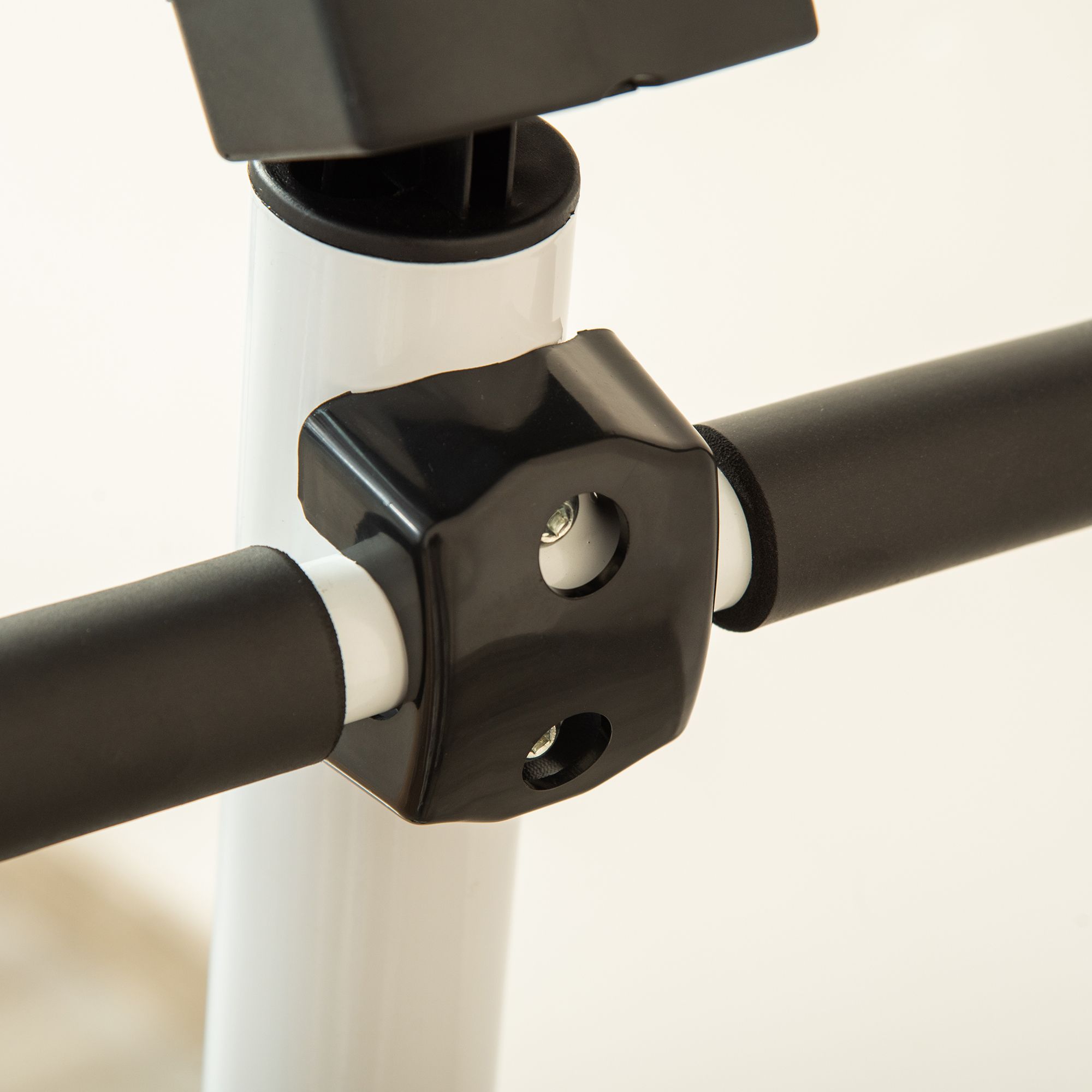 Detail van de handvatten van de stepper. Zwarte handvatten, wit metaal. Verbindingselement.