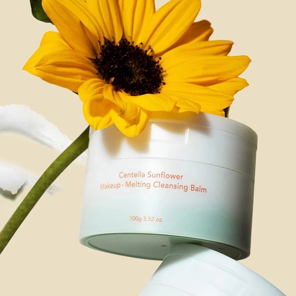 Pot blanc avec nom du produit et tournesol. Inscription : Centella Sunflower Makeup-Melting Cleansing Balm.