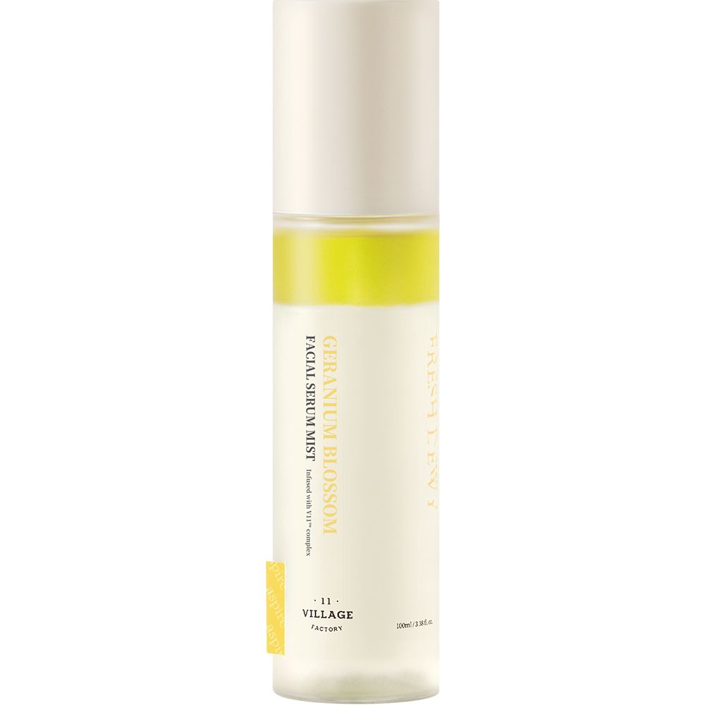 Cilindrische fles met gele band. Tekst: GERANIUM BLOSSOM, FACIAL SERUM MIST, -11- VILLAGE FACTORY. Witte dop.