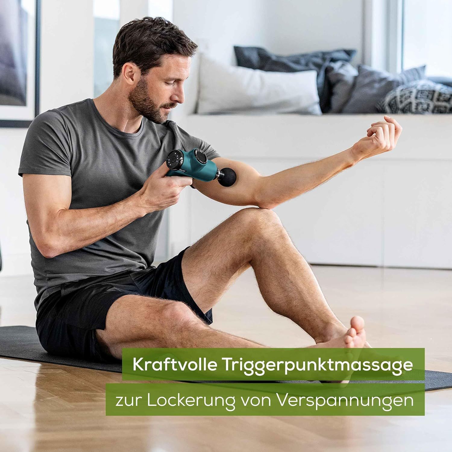 Personne assise utilise un pistolet de massage vert et noir sur son bras. Texte: Massage des points gâchettes pour soulager les tensions.