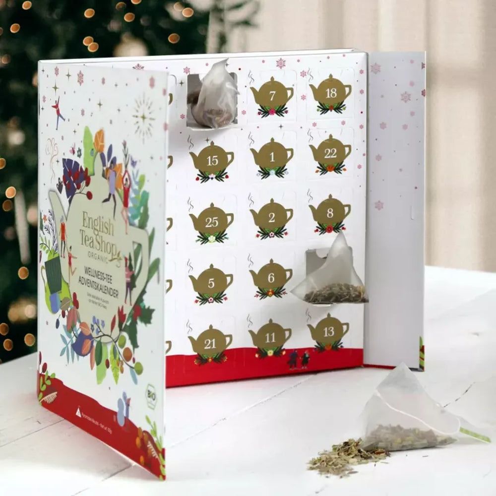 Calendrier de l'Avent ouvert. Intérieur avec motifs de théières et chiffres. Sachet de thé visible. Bord rouge.