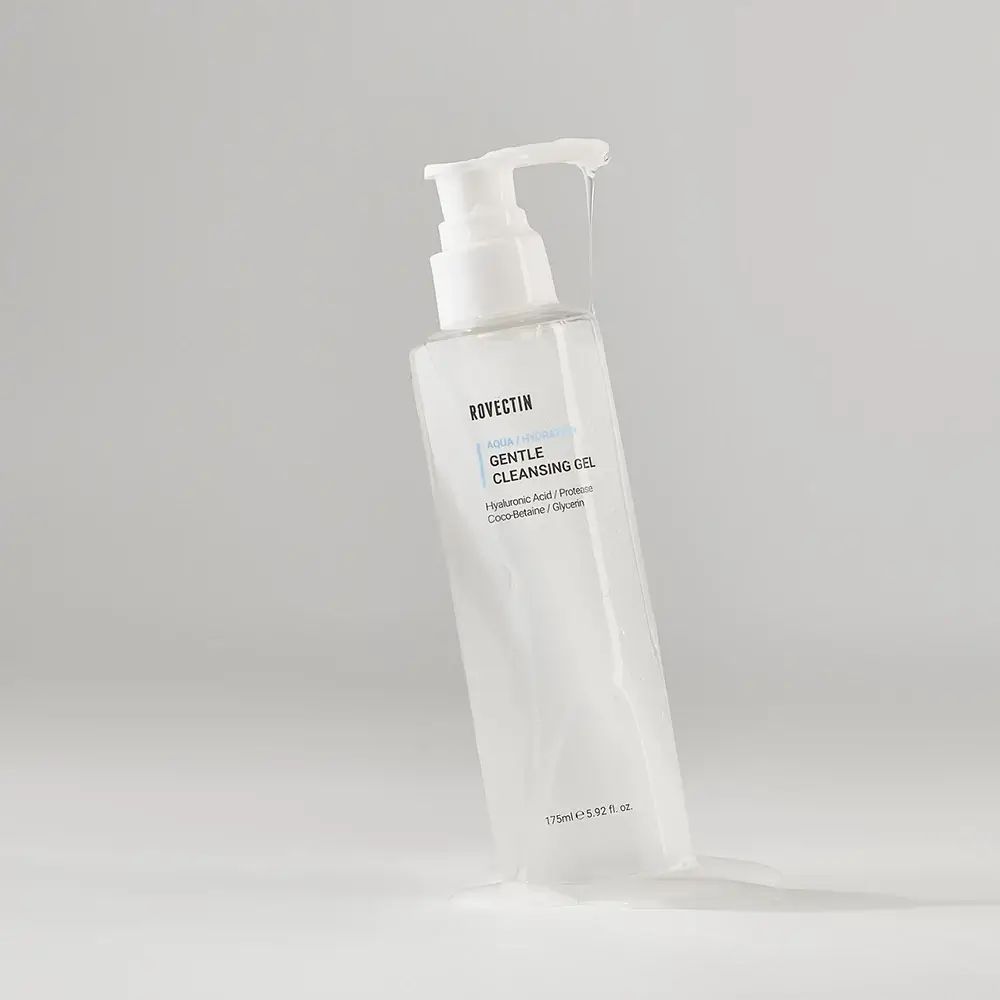 Schuin geplaatste transparante fles met witte pomp. Product: ROVECTIN Aqua Hydration Gentle Cleansing Gel. Vloeistof druppelt.