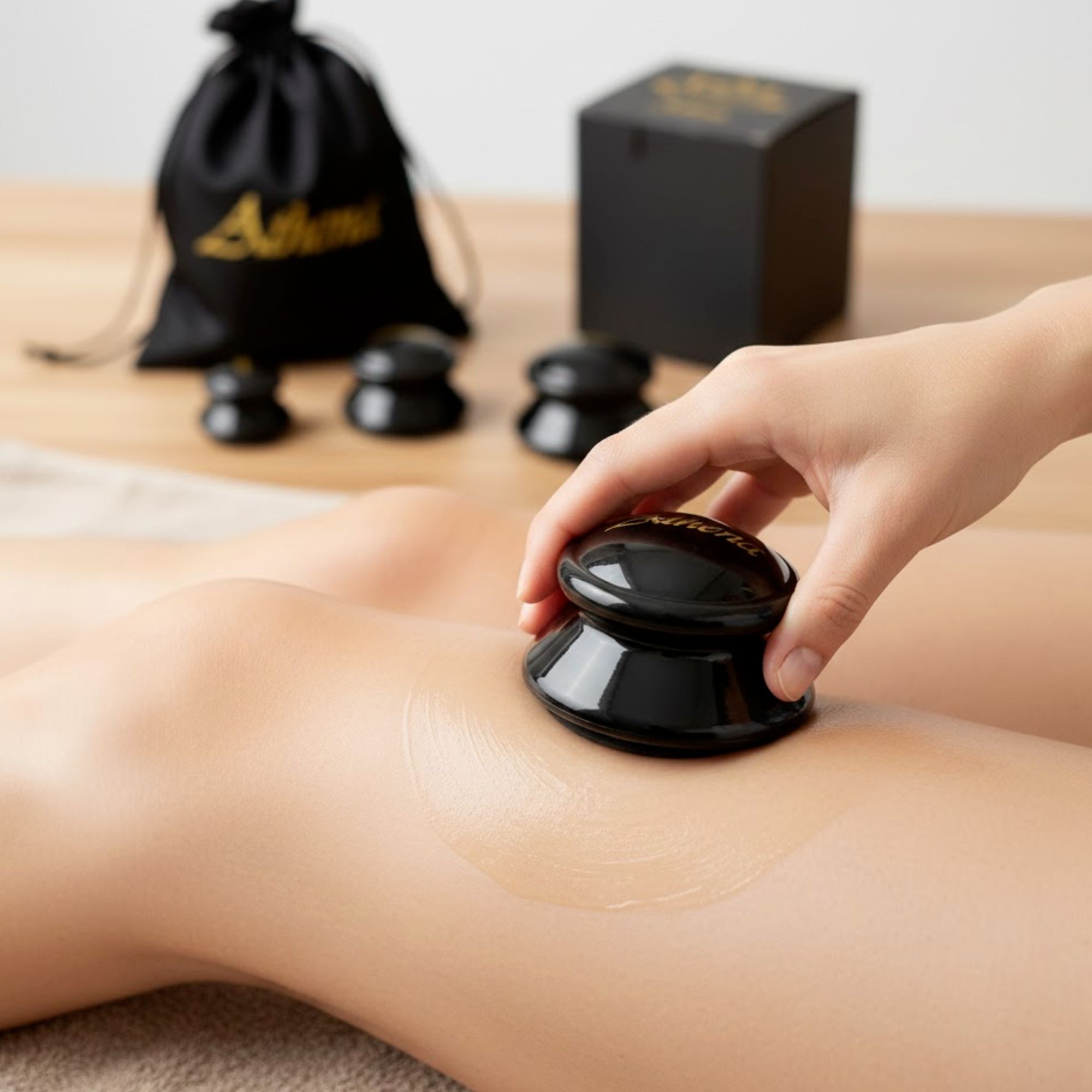 Hand houdt een zwarte cupping cup op een been. Er is een vloeistof zichtbaar op het been.